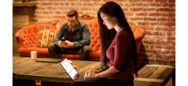 Étudiant sur un ordinateur portable et étudiant travaillant sur son canapé